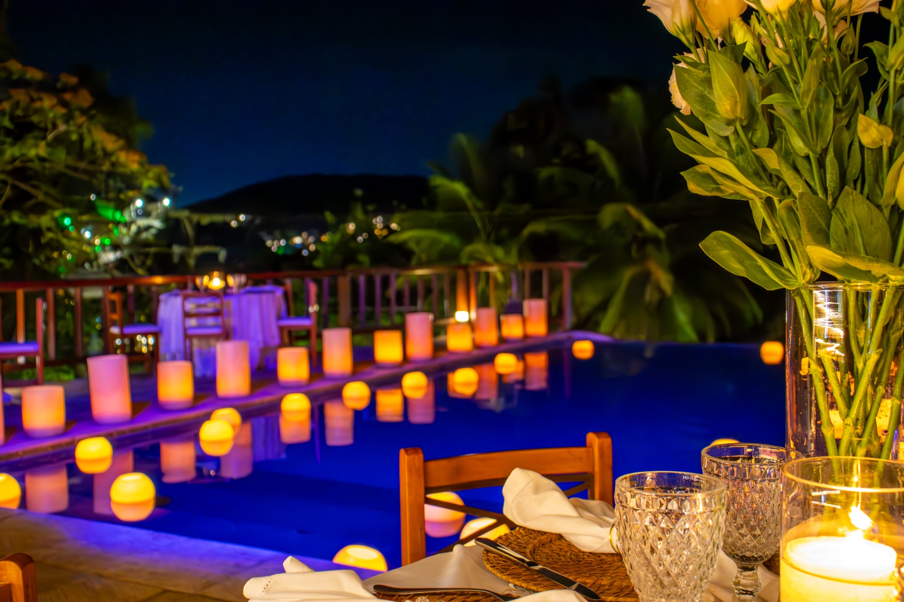 Mesa à beira da piscina com velas flutuantes no Bahiamarela